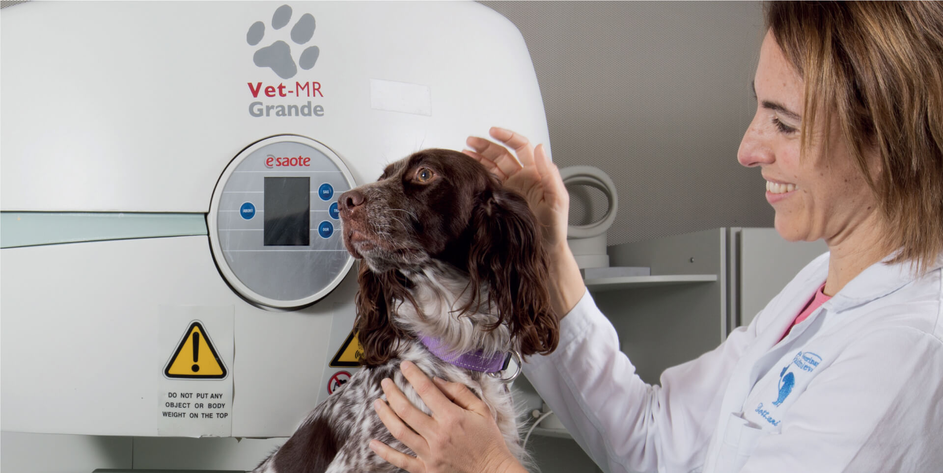 Veterinaria con un perro junto a un escáner MRI veterinario dedicado