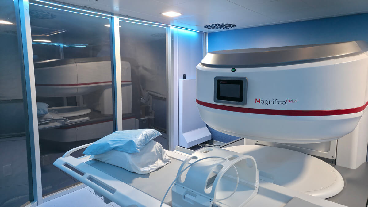 Sala de control MRI con ventana de observación blindada que ofrece una vista clara de la sala del escáner